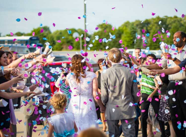 newly wed couple surrounded by people throwing confetti