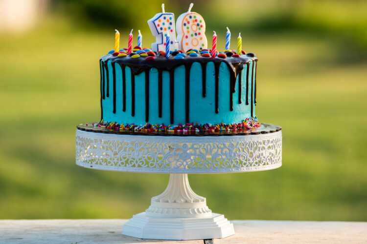 blue and white cake with happy birthday candles