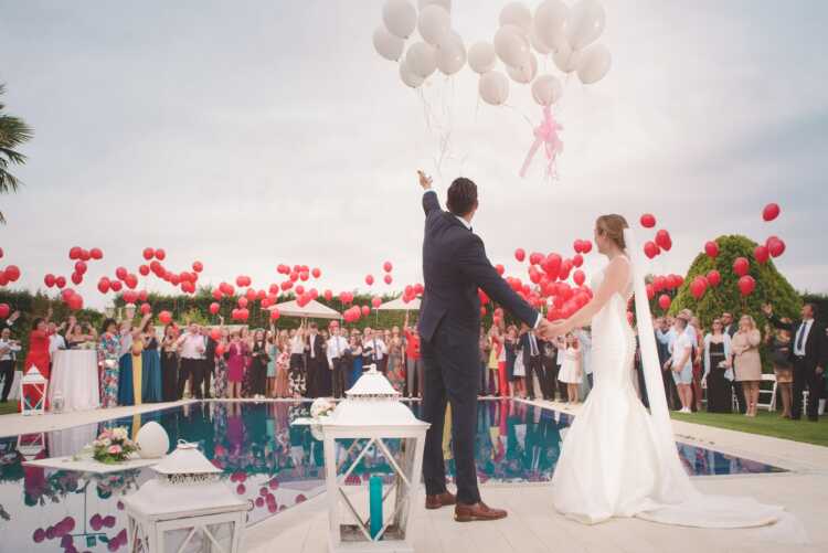 photo of a man and woman newly wedding holding a balloons