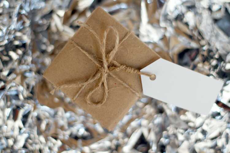 a gift wrapped in brown paper with a white tag