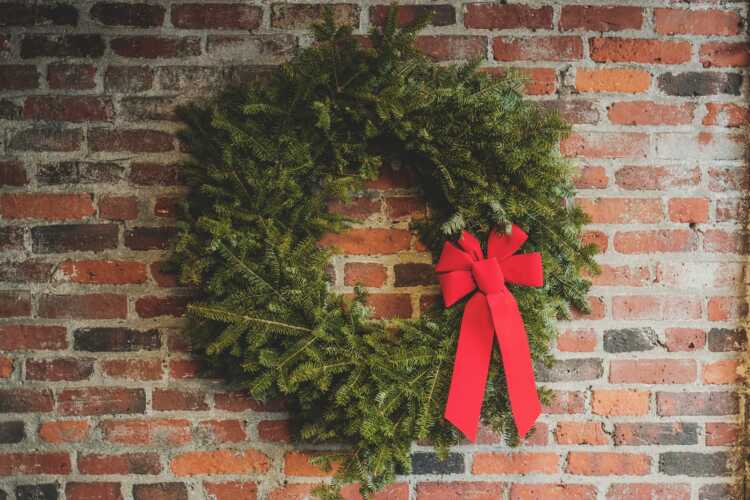 green wreath hang on wall brick